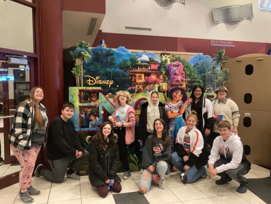 Photo of students standing in front of a movie poster